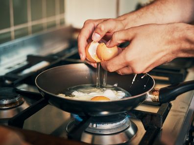 Frying eggs in kitchen