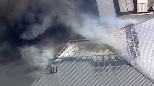 Fire is tearing through the roof of the property. (9NEWS)