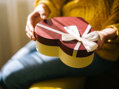 Young woman holding valentine day gift box