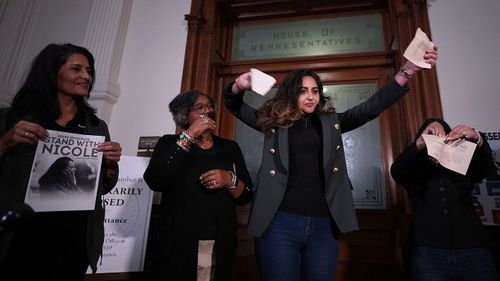 Democratic Texas state Rep. Mihaela Plesa, centre, and Rep. Cassandra Garcia Hernandez, right, tear up their 'permission slips' outside of the House Chamber.