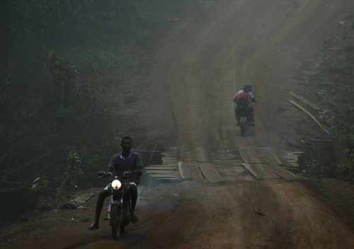 Residents motorcycle amid smoke from forest fires at dawn in the Vila Nova Samuel region, along the road to the National Forest of Jacunda, near the city of Porto Velho. Experts from the country's satellite monitoring agency say most of the fires are set by farmers or ranchers clearing existing farmland, but the same monitoring agency has reported a sharp increase in deforestation this year as well. 