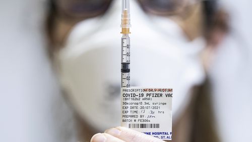 Staff preparing Pfizer vaccine doses inside the Melbourne Showgrounds COVID-19 Vaccination Centre.