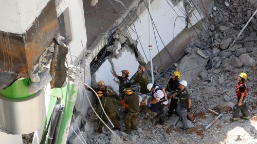 Rescuers pull a person out from the collapsed building. (AFP)
