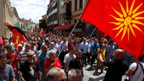Macedonian demonstrators march with their national flag. (AP).