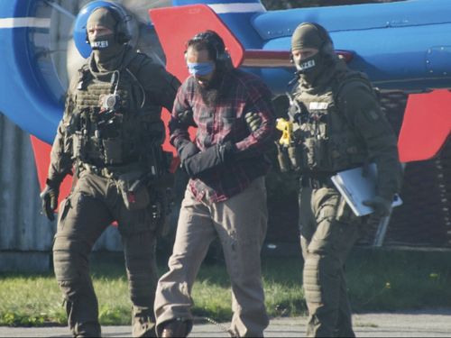 Photographs showed a blindfolded man being led by police to a helicopter.