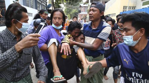 A man is carried after police dispersed protesters in Mandalay, Myanmar on Saturday, Feb. 20, 2021