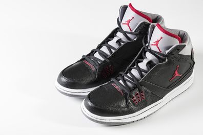 New York, USA - September 16, 2012: Black Air Jordan sneakers isolated on white background. Air Jordans are a brand of shoes and athletic apparel designed and produced by Nike for the now-retired basketball player Michael Jordan.