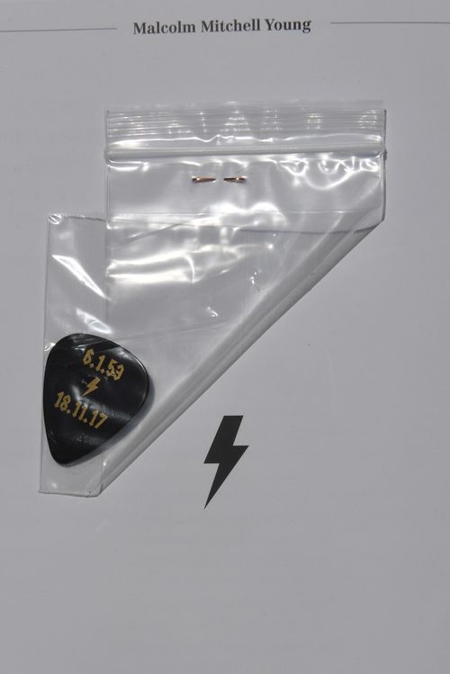 Special guitar picks were handed out with the programs at Young's funeral. (AAP)