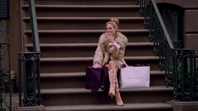 Carrie Bradshaw's NYC apartment stoop. Carrie (played by Sarah Jessica Parker) waits at the foot of her stoop with a designer shopping bag