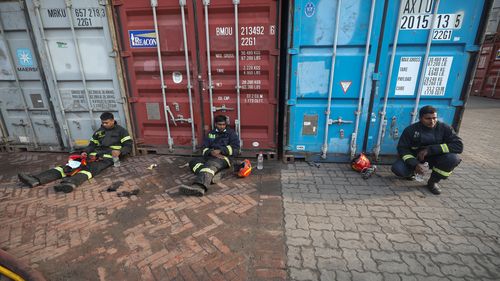 Exhausted firefighters take a break after trying to contain a fire broke out at the BM Inland Container Depot, a Dutch-Bangladesh joint venture, in Chittagong, 216 kilometres southeast of capital, Dhaka, Bangladesh, early Sunday, June 5, 2022. (AP Photo)