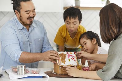 Liaw family building a gingerbread house