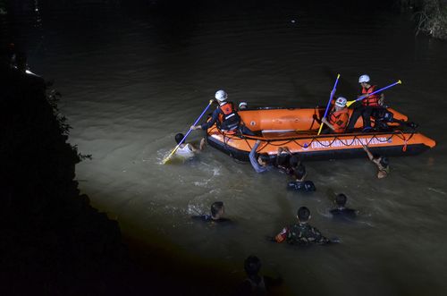Rescuers search for victims of drowning along the river in Ciamis, West Java, Indonesia,  (AP Photo/Yopi Andrias)