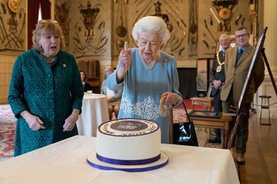 Queen Elizabeth cuts a cake to celebrate the start of the Platinum Jubilee during a reception in the Ballroom of Sandringham House on February 5, 2022 in King's Lynn, England