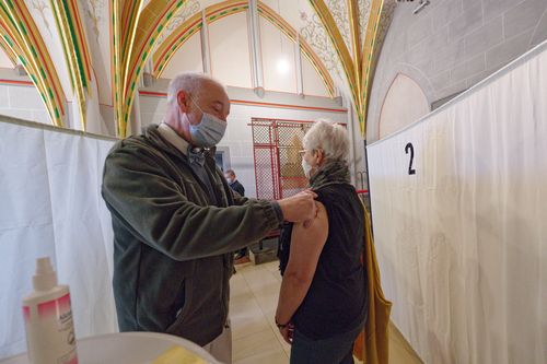 A woman receives a vaccination during a Christmas vaccination campaign in the Dreikönigensaal of Cologne Cathedral. 24 December 2021, North Rhine-Westphalia, Cologne