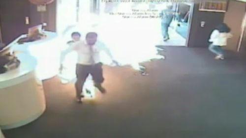 A bank staff member can be seen running for his life as the accused lunges forward. (9NEWS)