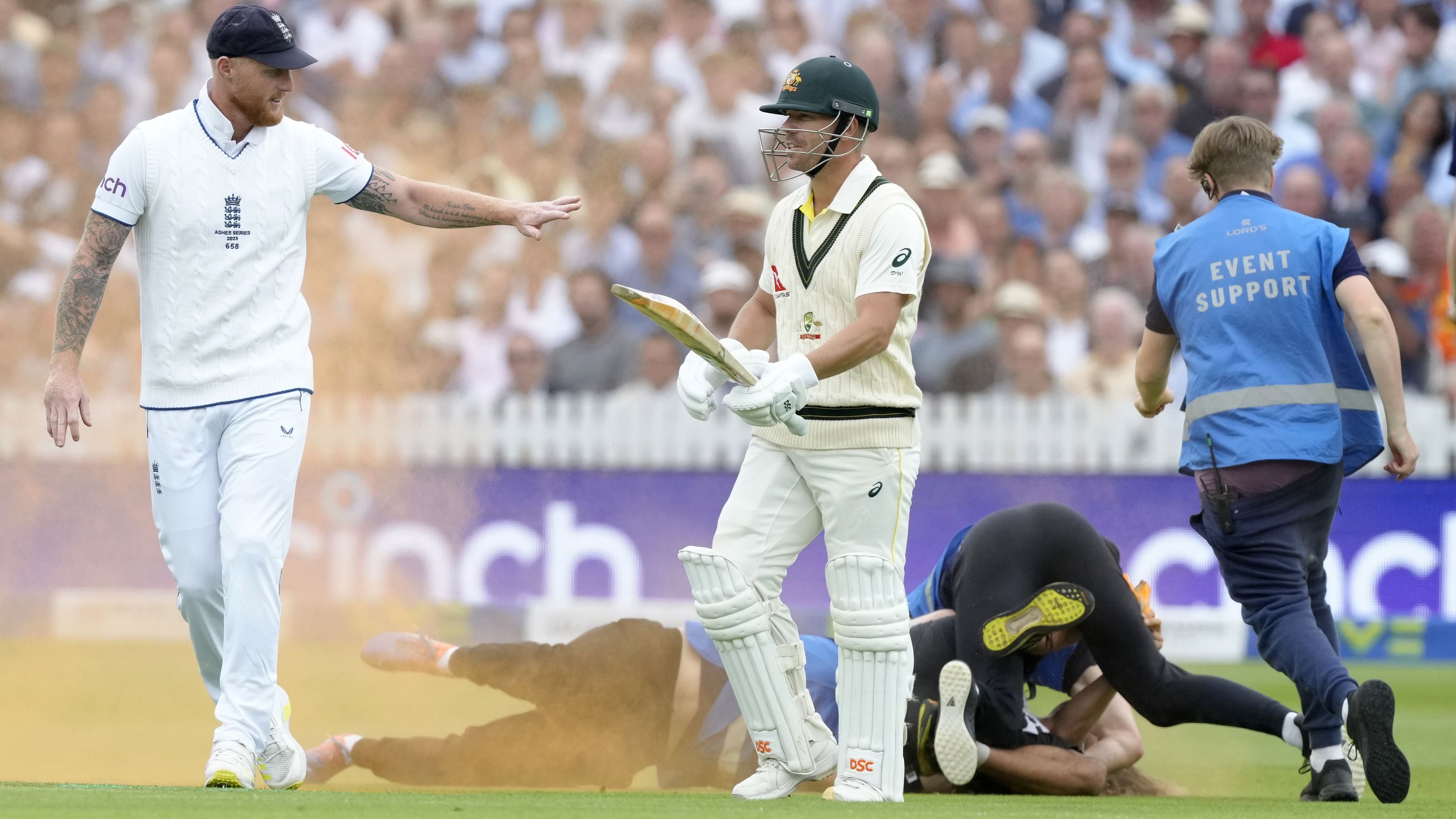 England&#x27;s Ben Stokes (left) and Australia&#x27;s David Warner react as a Just Stop Oil protester is apprehended after they threw colored powder on the pitch during day one of the second Ashes Test at Lord&#x27;s.