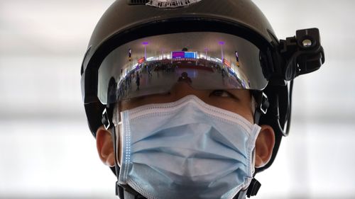 A police officer wearing a face mask to protect against the spread of new coronavirus stands guard at Wuhan Tianhe International Airport in Wuhan in central China's Hubei Province