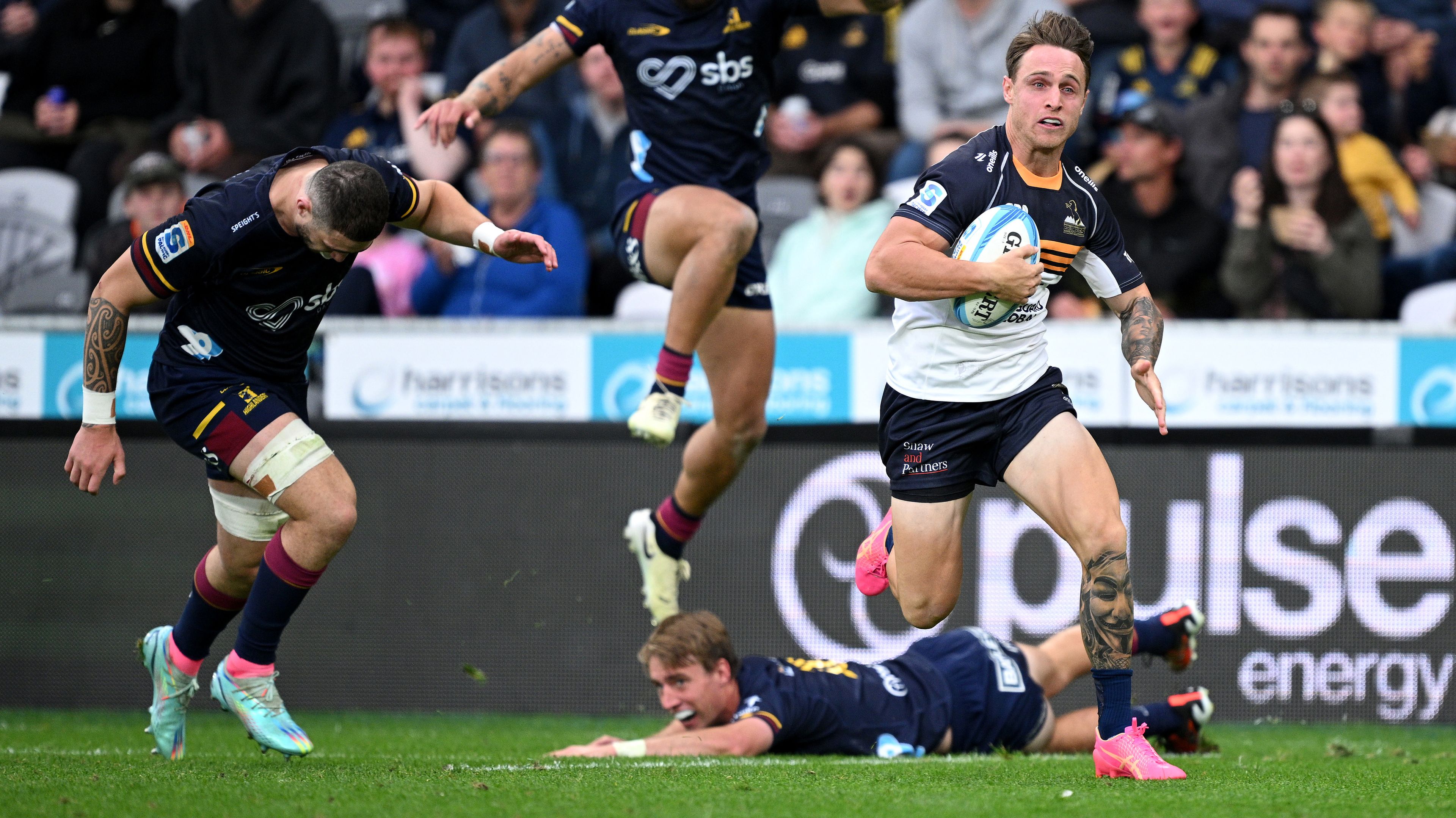 Corey Toole of the Brumbies charges towards the try line to score.