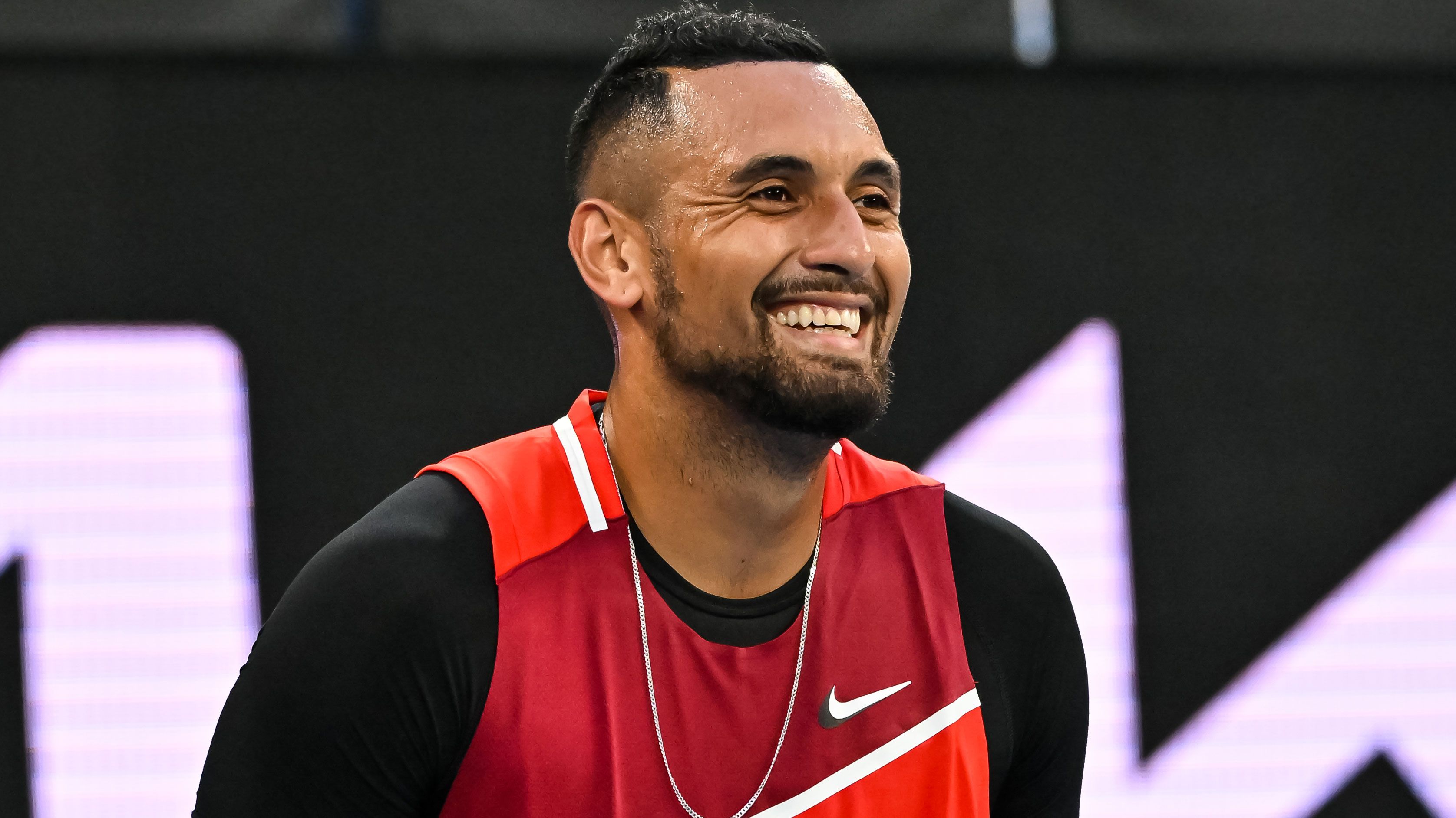 Nick Kyrgios smiles during his round one appearance at the 2022 Australian Open.