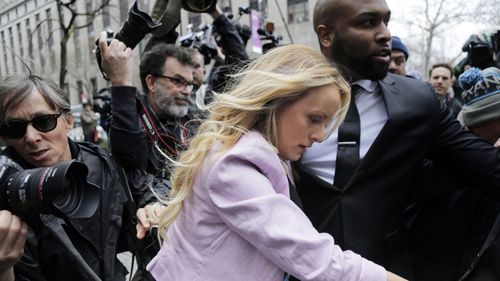 Photographers knocked over barricades as they scrambled in the streets outside the Manhattan courthouse to snap pictures of her as Stormy Daniels arrived. (AP)