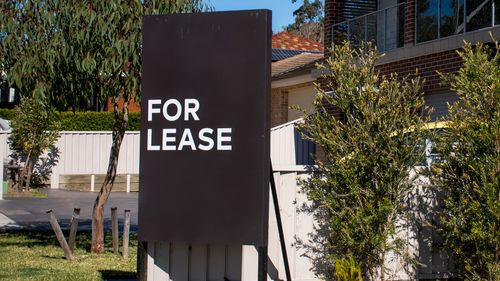 For lease sign on a blue display outside of a resedential building in Australia. Investment property real estate concept