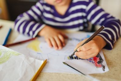 Cute boy drawing at home. Lifestyle photo.