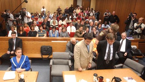 Michael Peterson, right, is handcuffed by Durham Sheriff's officer Bryan Mister in2003 after being found guilty of first degree murder in the death of his wife, Kathleen Peterson. Defence attorney David Rudolf is standing to Mr Peterson's right. His conviction was later overturned.