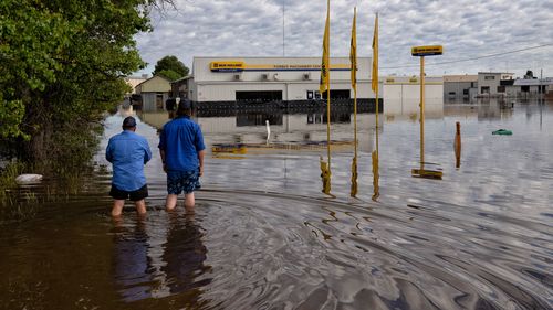 Workers inspect flooded businesses on the Newell Hwy on the northern part of Forbes.