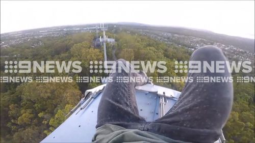 The teenagers dangle their feet over a satellite dish before climbing back down, seemingly unhurt. Gold Coast Councillor Dawn Crichlow has slammed the stunt as “too dangerous”. (9NEWS)