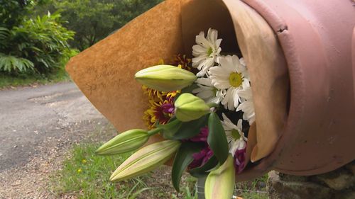 Flowers left by the house where twins were killed in a fire near Byron Bay, NSW.