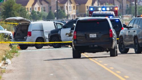 Police surround a white van believed to have been used in the shooting spree.