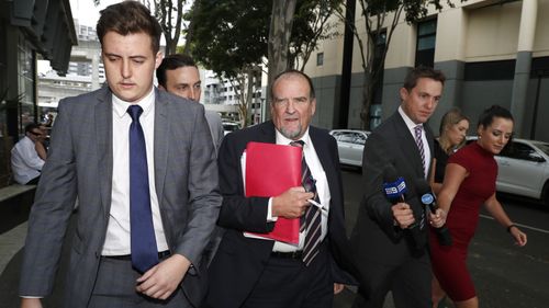 Dan Creevey (centre), solicitor for the senior Gold Coast police officer exits the court. (AAP)