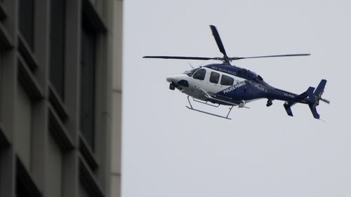 A New South Wales police helicopter patrols the sky over the central business district in Sydney.