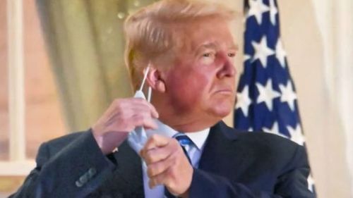 Outgoing president Donald Trump is pictured removing his mask after he left the hospital where he was being treated for the coronavirus.