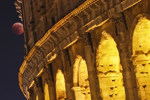The blood moon peaks behind the Colosseum in Rome. Picture: AAP