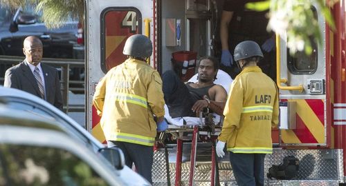 Alleged shooter Gene Atkins is taken into the back of an ambulance. Picture: AP