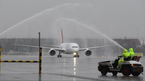 Sydney airport workers look on as Qantas' new Boeing 787 Dreamliner aircraft arrives on its first flight into Sydney. (AAP)