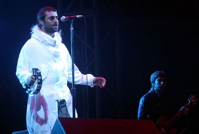 Liam Gallagher (L) and Noel Gallagher of Oasis perform on the Pyramid Stage during the 2004 Glastonbury Festival, on June 25, 2004