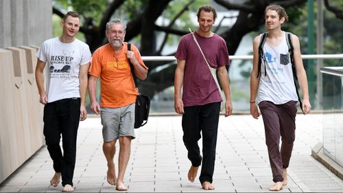 Convicted trespassers Andrew (Andy) Paine, Jim Dowling, Tim Webb and Franz Dowling are seen outside the Federal Court in Brisbane. (Image: AAP)