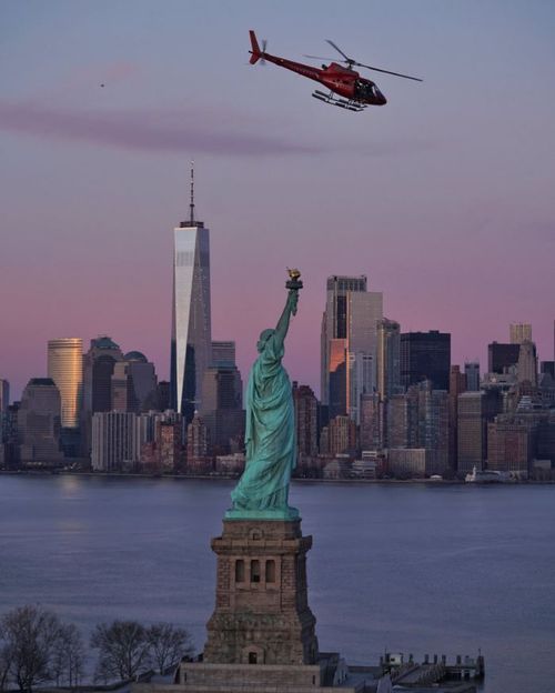 The helicopter is seen over the Statue of Liberty, just minutes before it crashing into East River. (Eric Adams Photography)
