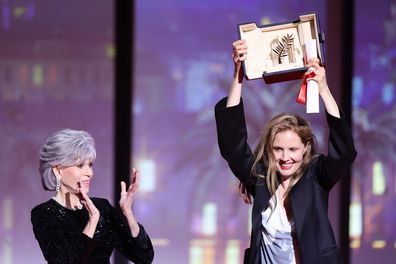 Justine Triet (R) receives The Palme D'Or Award for 'Anatomy of a Fall' from Jane Fonda (L) during the closing ceremony during the 76th annual Cannes film festival