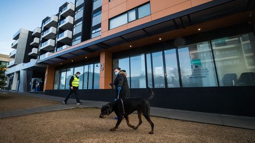 Staff from DHHS (Department of Health and Human Services Victoria) are seen walking the dogs of residents from the Ariele Apartments in Maribyrnong in Melbourne.