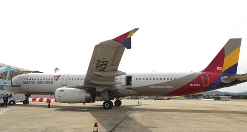 An Asiana Airlines plane is parked as one of the plane's doors suddenly opened at Daegu International Airport in Daegu, South Korea, Friday, May 26, 2023. 