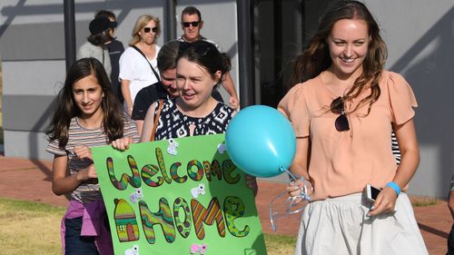 A group of girls welcome home Mallacoota bushfire evacuees at the Somerville Recreation Centre in Somerville south-east of Melbourne, Saturday, January 4, 2019. The group arrived at the port of Hastings on MV Sycamore this morning.