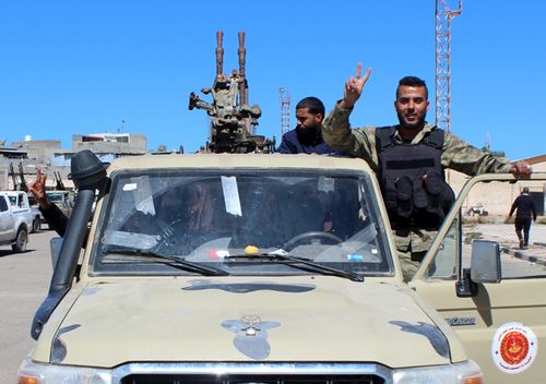 Militants, reportedly from the Misrata militia, flash the victory sign as they gather before heading to the frontline to join forces defending the capital, in Tripoli, Libya