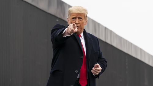 ABD Başkanı Donald Trump, izleyicilere işaret ediyor.