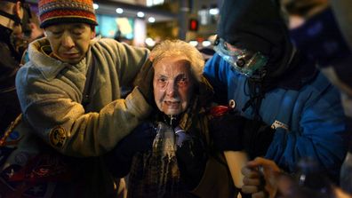 Seattle activist Dorli Rainey, 84, reacts after being hit with pepper spray