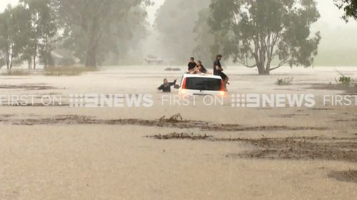 Three other adults and children were trapped on another sinking car. (9NEWS)
