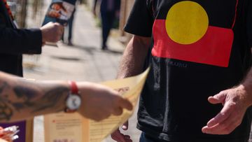 Volunteers hand &quot;how to vote&quot; cards