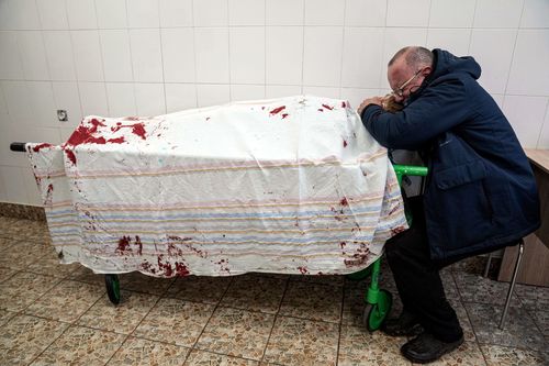A father cries on his son's lifeless body in Ukraine